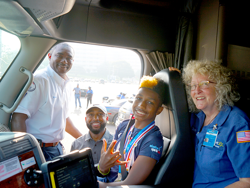 Smiling from inside the cab of a Walmart 18-wheeler is Mississippi’s Children’s Miracle Network Hospitals Champion KJ Fields, flanked by driver Ricky Sharp, left, his father Kelvin Fields and driver Devan Griffin.